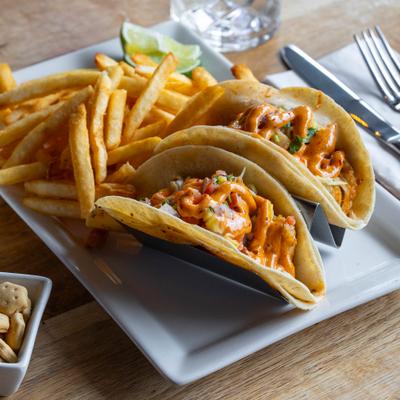 Island tacos served with french fries and lime wedges.