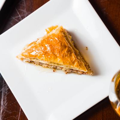 Slice of baklava on square white plate.