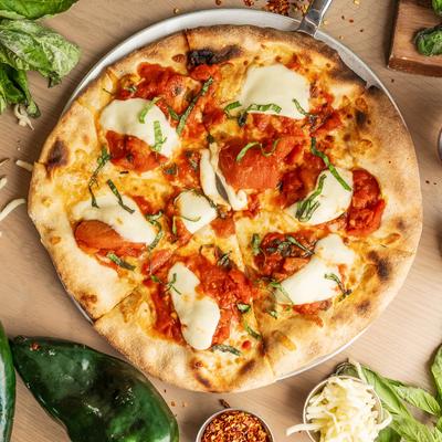 A whole pizza on a plate.