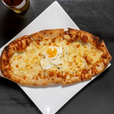 Cheese pizza with a sunny side up egg in the center.