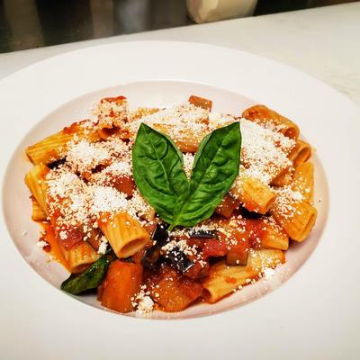 Rigatoni in a tomato sauce with grated cheese and basil leaves.
