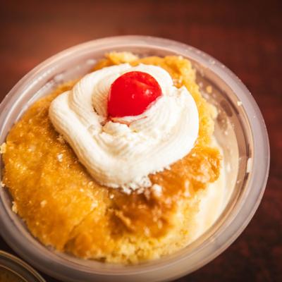 Pineapple cake with whipped cream and a cherry.