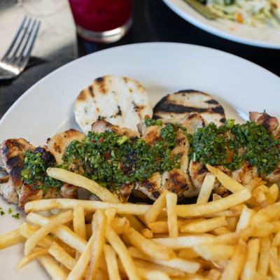 Grilled chicken skewers served with french fries.