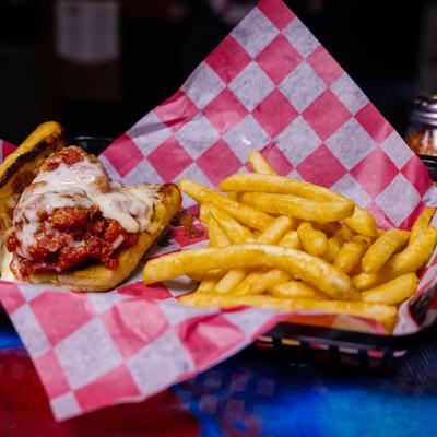 Meatball sandwich with a side of fries.