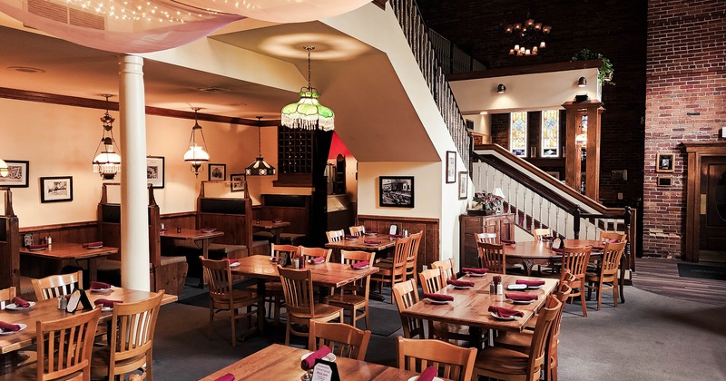 Interior space, dining area with set tables, stairs for the second floor