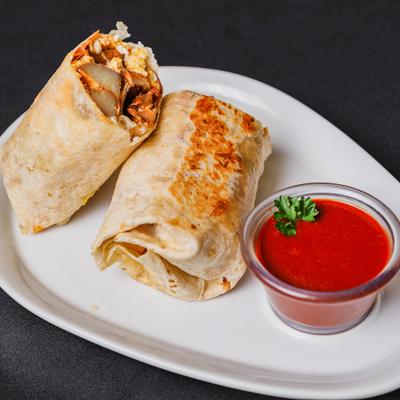 Breakfast Burrito served with a dipping sauce on the side.