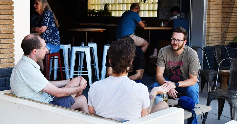 Outdoors, a group of people engaged in a conversation in a seating area