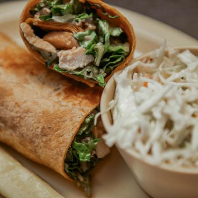 Chicken Caesar wrap served with coleslaw.