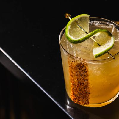 Tomtum Sunruse cocktail with a chili rim and lime garnish.