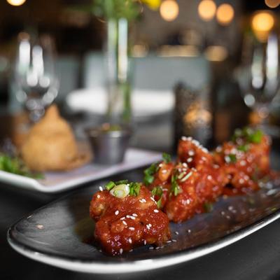 Close-up of fried cauliflower florets with a soy-tomato glaze.