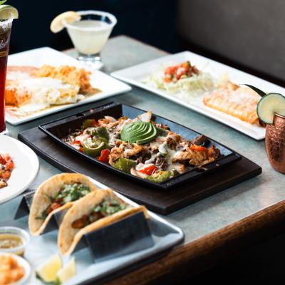Assortment of dishes served on the table alongside cocktails.