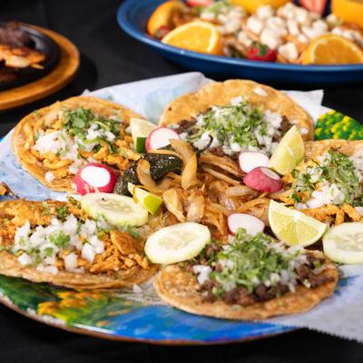 Mexican street tacos loaded with marinated meats and various toppings.