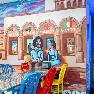 A large wall mural, tables and chairs.