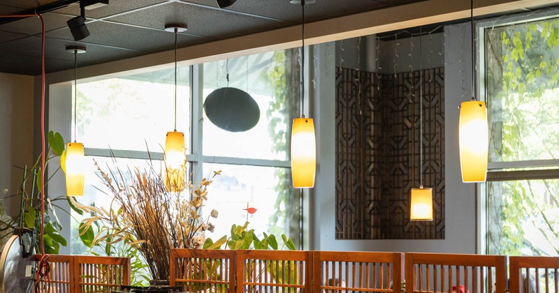 Interior featuring long cylindrical pendant light fixtures over the dining area