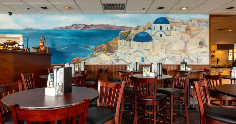 Inside, restaurant seating area with tables and a wall mural