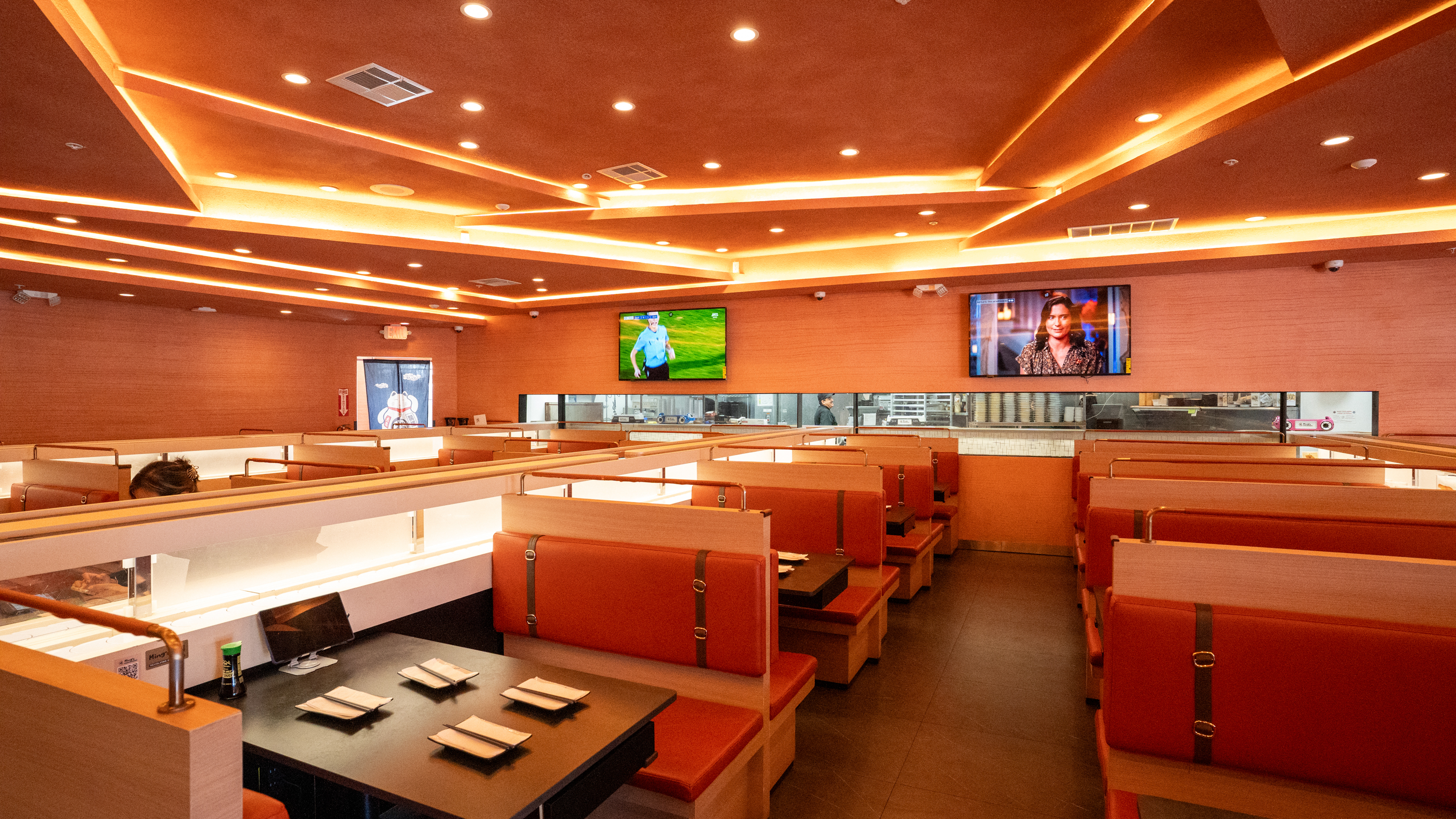 Interior, diner area, booths, tv screens on wall behind