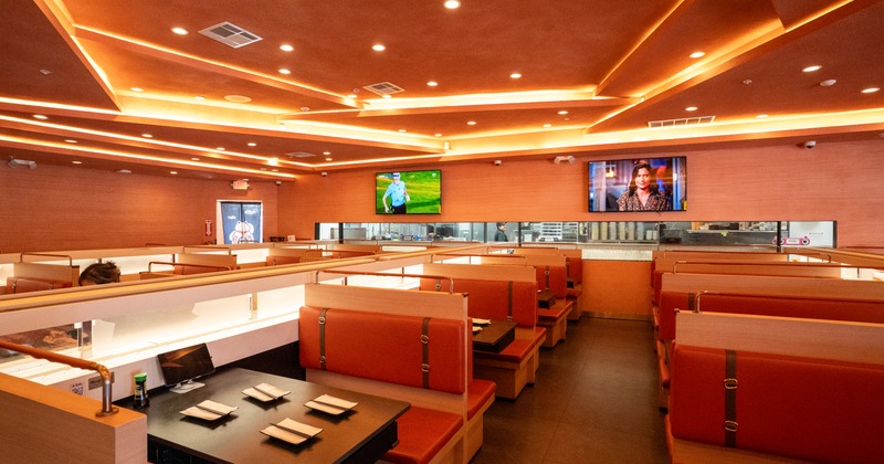 Interior, diner area, booths, tv screens on wall behind