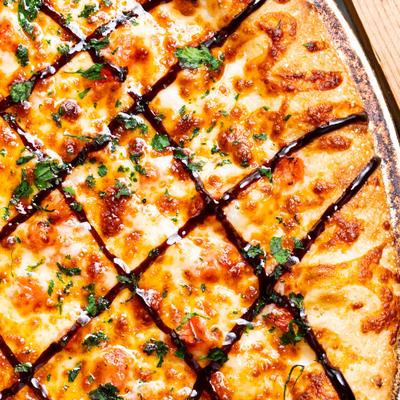 Margherita Pizza, with garlic butter base, tomato, fresh basil, and balsamic glaze.