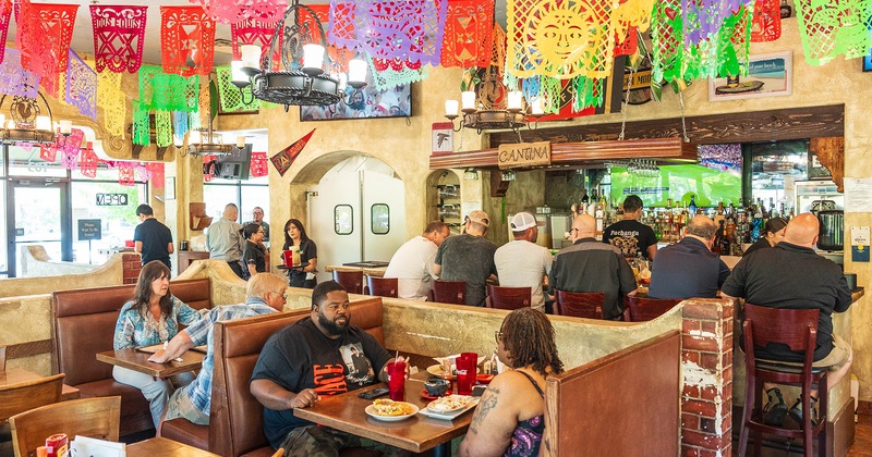 Restaurant interior, dining area and bar, guests enjoying their food and drinks