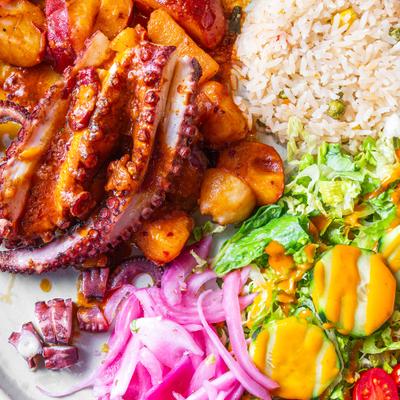 Grilled octopus served with rice, roasted potato and a mix salad.