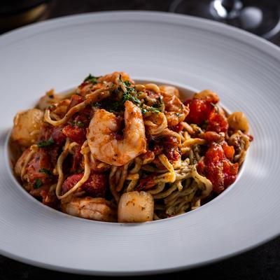 Sauteed shrimp and scallops pasta with tomato sauce and basil pesto.