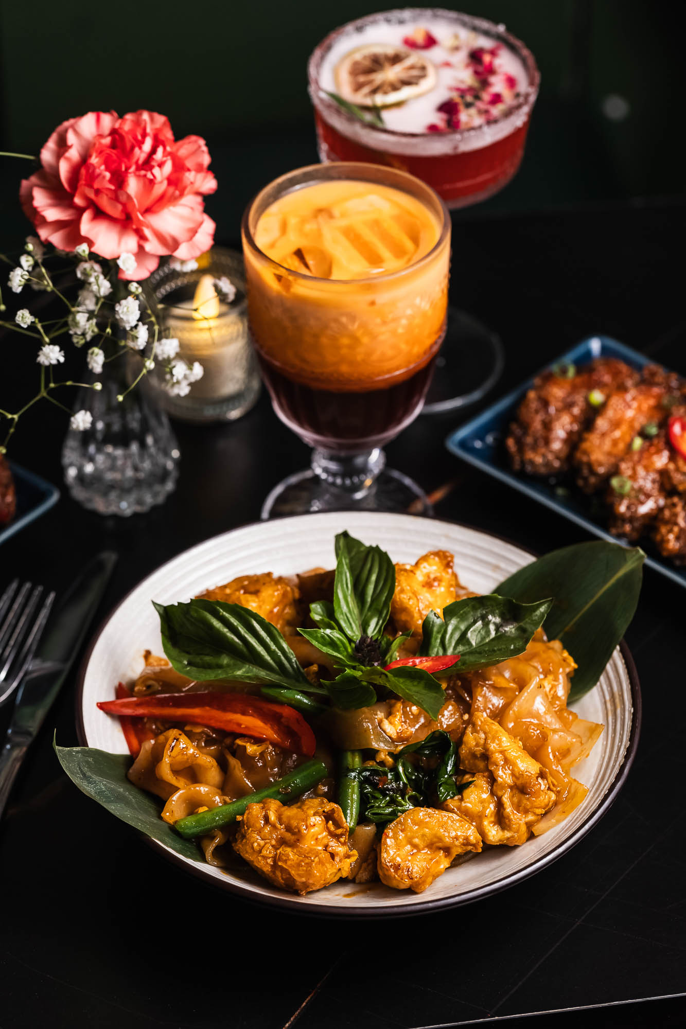 Drunken noodles with tofu, served with a Thai iced tea