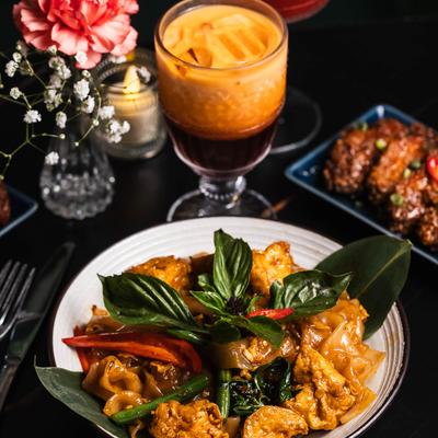 Drunken noodles with tofu, served with a Thai iced tea.