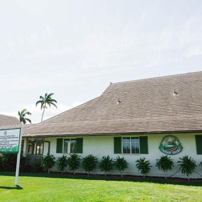 Restaurant building with sign and surrounding greenery.