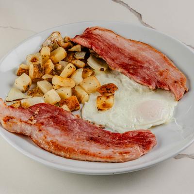 Breakfast plate with eggs, homefries and bacon.