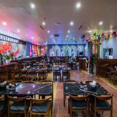 Spacious dining area with tables, chairs, and hanging lanterns.