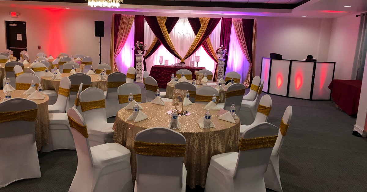 A decorated banquet hall set up for a formal event, likely a wedding or party