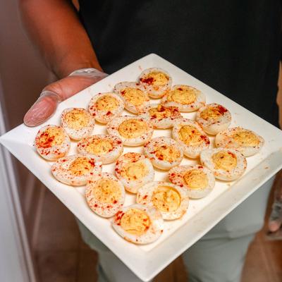 A server holding a plate with deviled eggs.