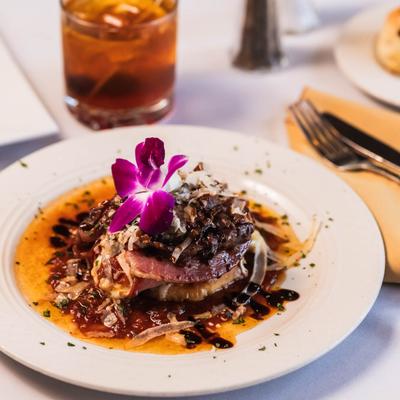 Seared prosciutto wrapped mozzarella with caramelized onions.