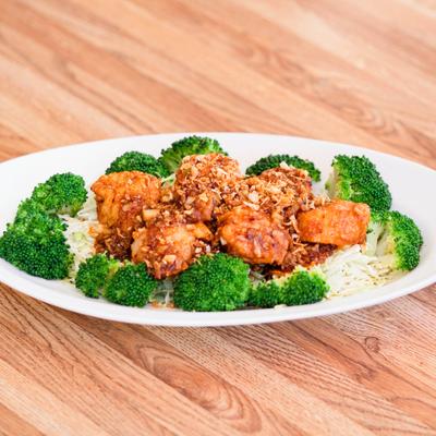 Garlic Scallops served on a bed of cabbage with steamed broccoli on the side.