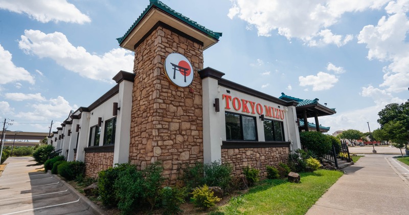 The exterior, a Japanese-style restaurant with a stone facade and a traditional-looking roof