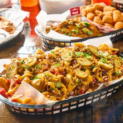 Steak Loaded Fries with food assortment on table.