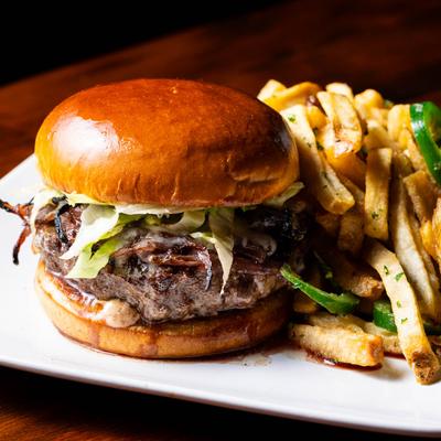 Burger with fries and jalapenos.
