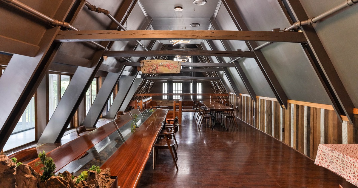 Interior, long table with chairs on the left, and windows letting in natural light