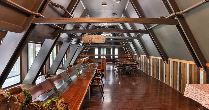 Interior, long table with chairs on the left, and windows letting in natural light