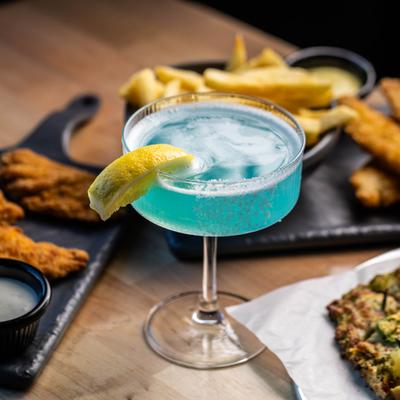 Hawaiian Lemon Drop cocktail served alongside food.