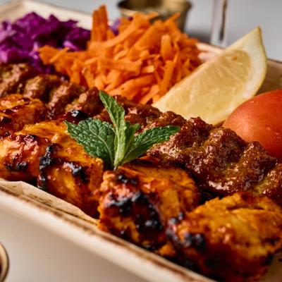 Mixed Grill platter with with shreder carrot and cabage, served with a lemon wedge.