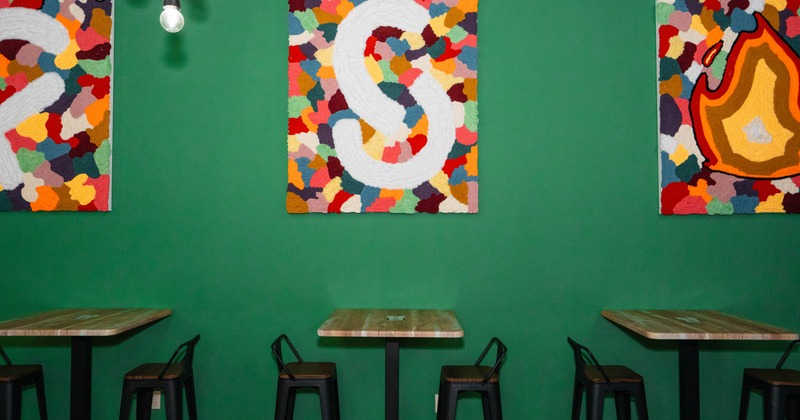 Interior, high tables and chairs near wall