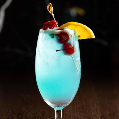 Blue Lagoon cocktail with citrus, cherries, and flower garnish.