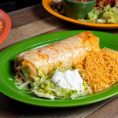 Fajita Burrito Combo with rice, lettuce, and sour cream on a green plate.