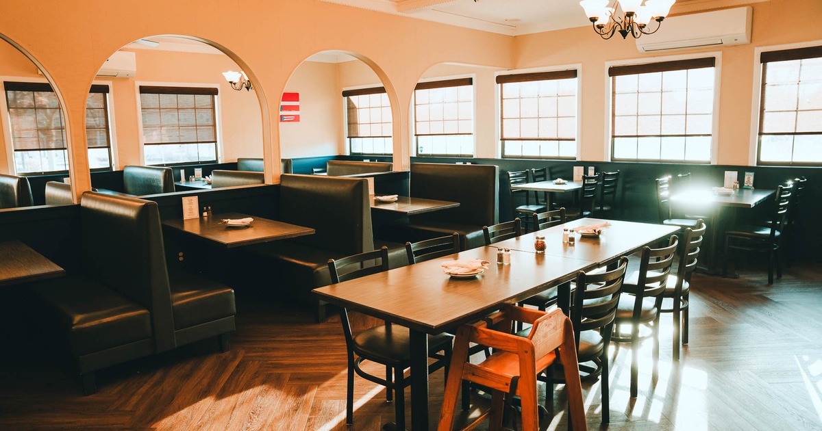 Interior, table with stools with booths behind