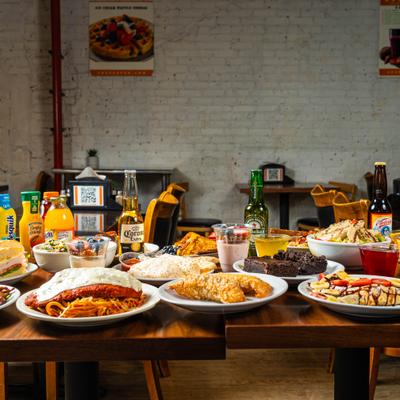 Restaurant table filled with assorted meals, desserts, and drinks.