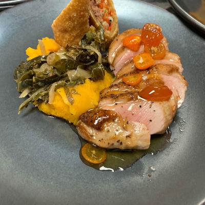 Sliced roasted pork with vegetables and a burrito