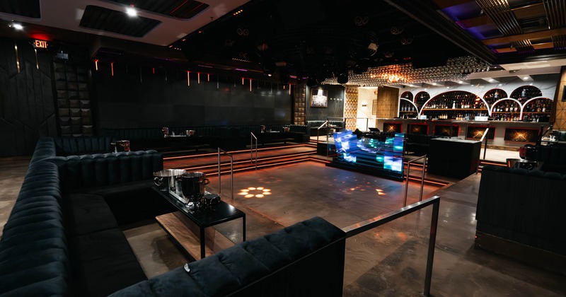 Interior, dancefloor with DJ booth, booths surrounding, bar in the back