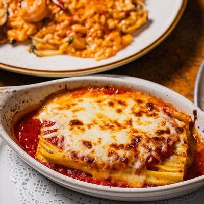 Lasagna plate and seafood dish plate on a table.