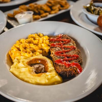 Meatloaf, served with mashed potatoes, gravy, and mac and cheese.